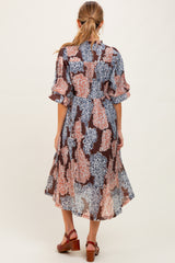woman wearing a floral maternity wrap dress with short sleeves and a flowing midi length, showing the back view