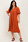 woman wearing an orange midi dress with a v-neck and puff sleeves, featuring a floral pattern