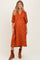woman wearing an orange floral print maternity dress with puff sleeves and a baby bump visible