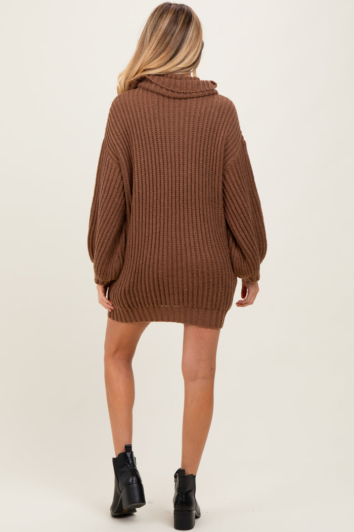 woman wearing a brown oversized knitted maternity sweater with a cowl neck and long sleeves