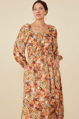 woman wearing a floral maxi dress with puff sleeves, square neckline, and an elastic waist with pockets
