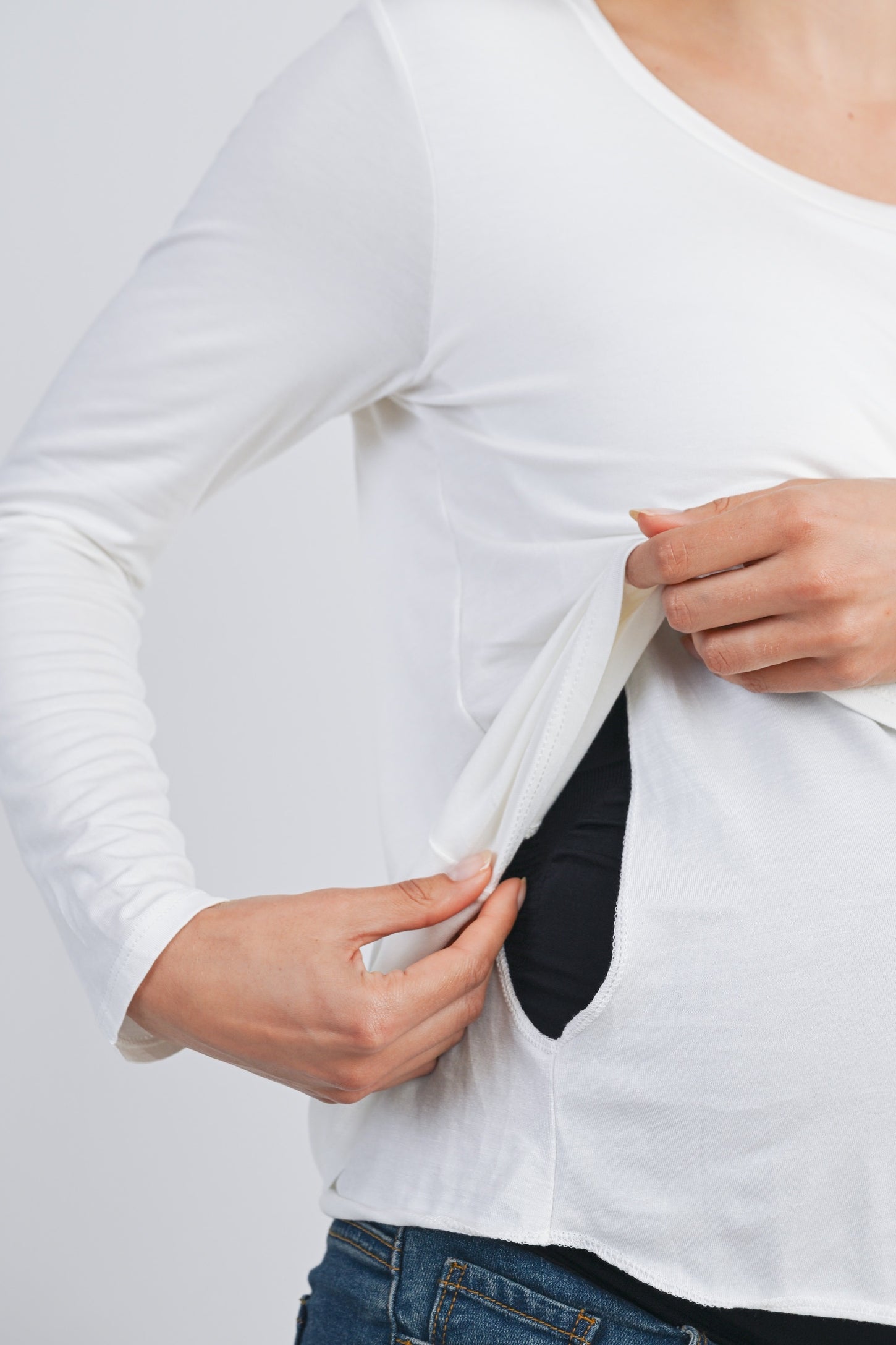 woman showing a white long sleeve maternity top with discreet nursing access openings