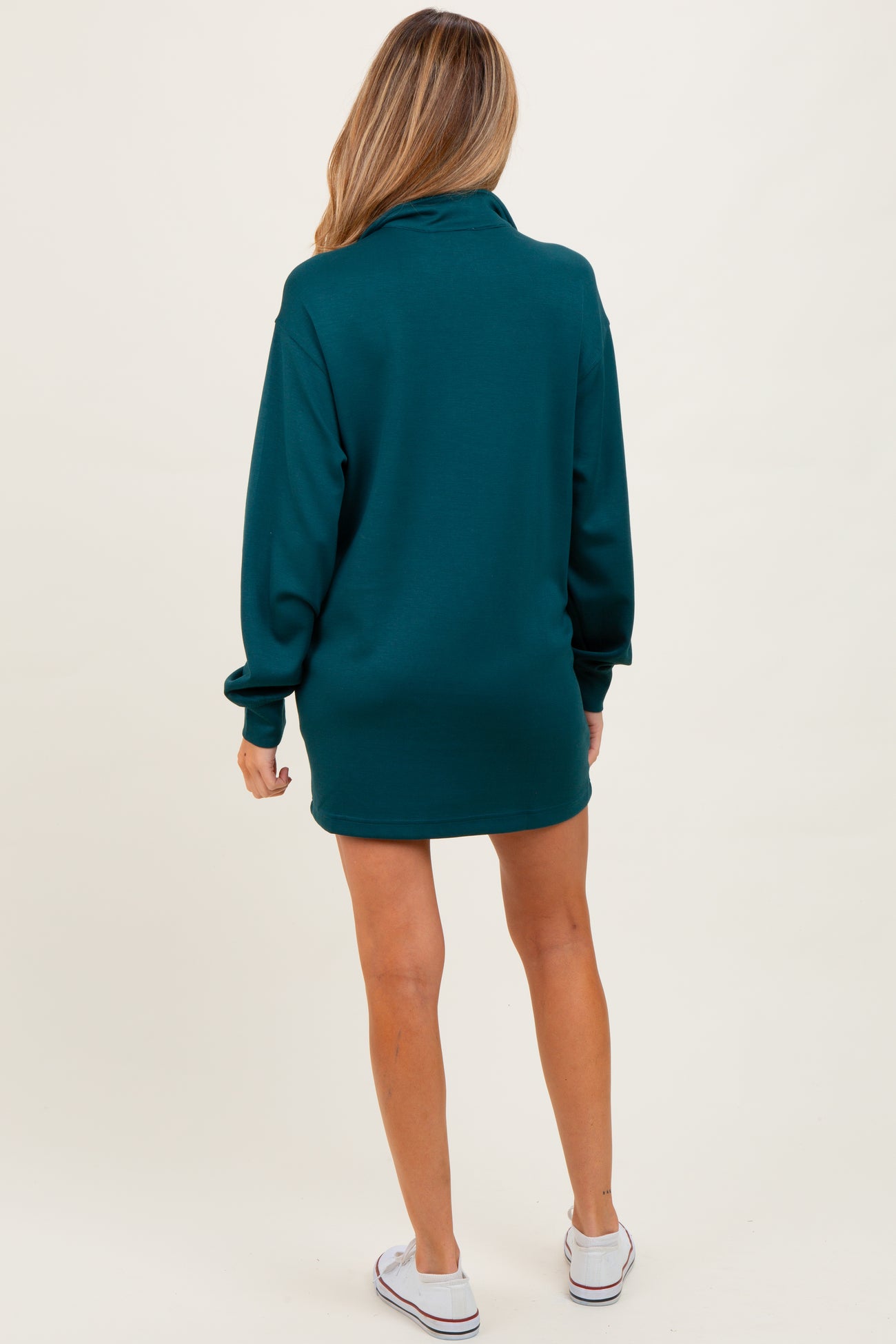 woman wearing a dark teal long sleeve maternity sweatshirt dress, view from the back