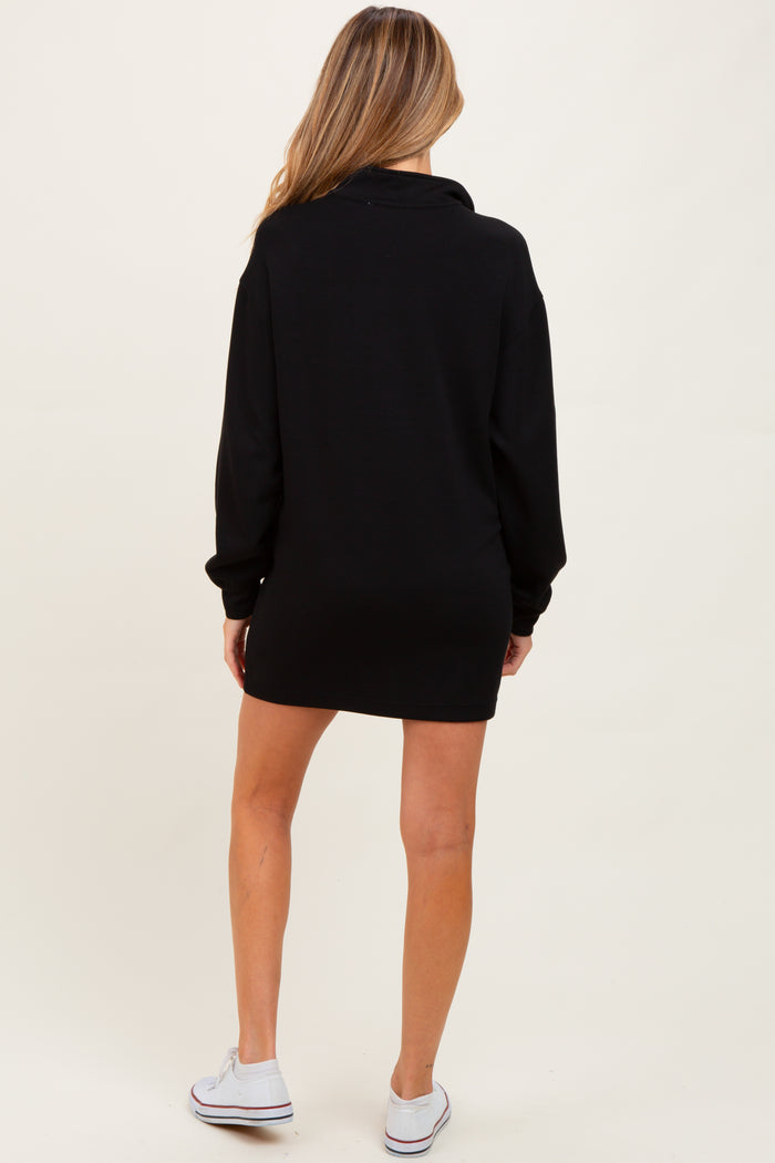 woman wearing a black maternity sweatshirt dress, shown from the back with long sleeves and a relaxed fit