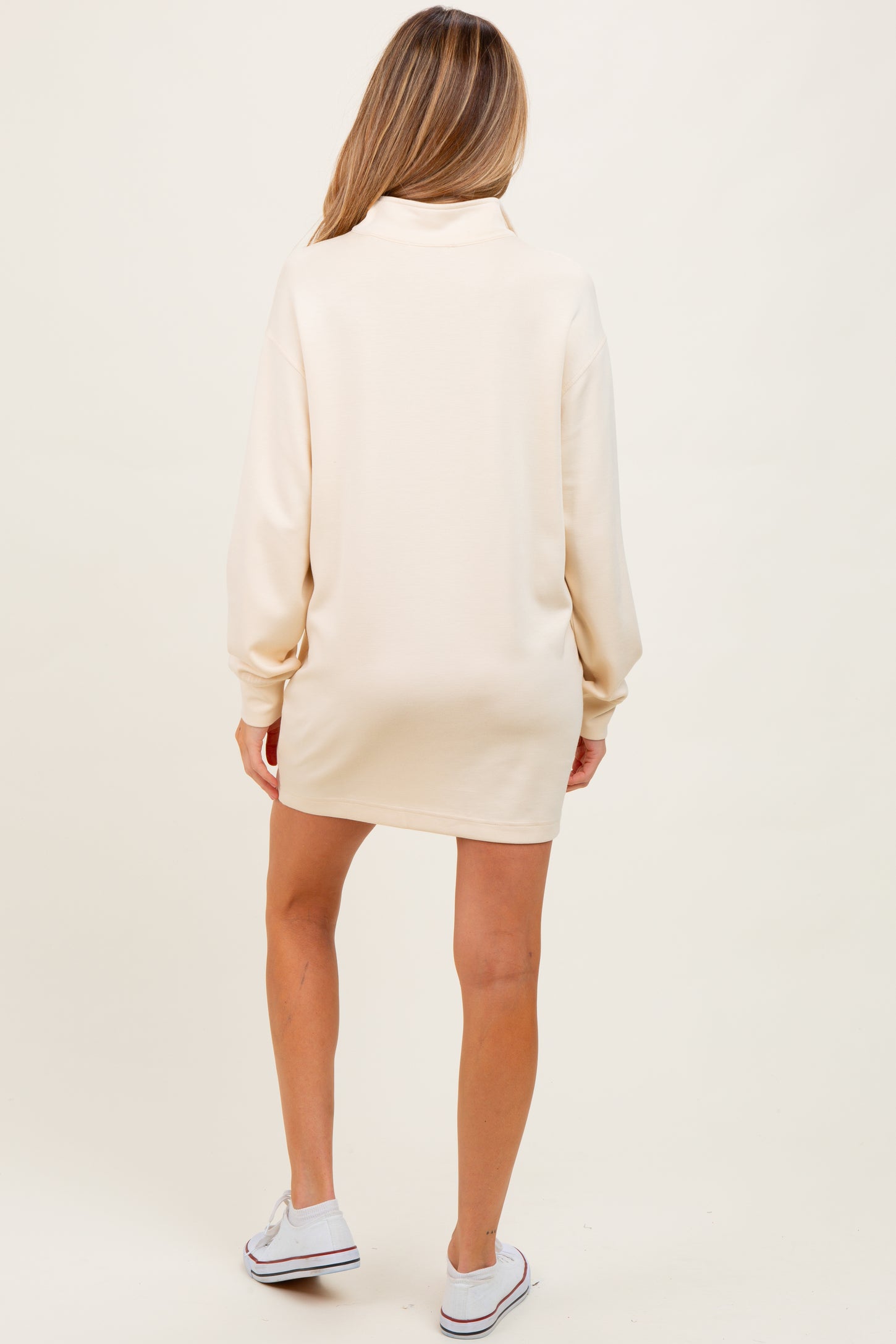 woman wearing a cream long sleeve maternity dress, shown from the back, with a relaxed fit and soft fabric