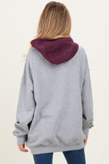 woman wearing a gray maternity hoodie with a maroon hood, viewed from the back, showing relaxed fit and casual style