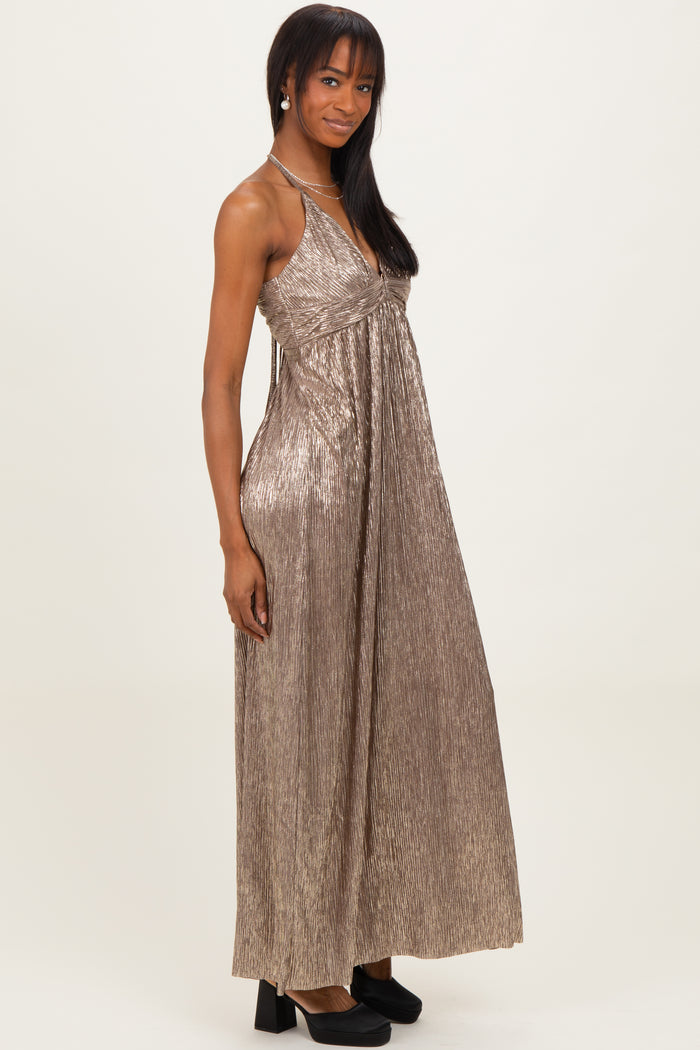 woman wearing a shiny gold maxi dress with a fitted bodice and flowing skirt, standing in profile with a neutral background