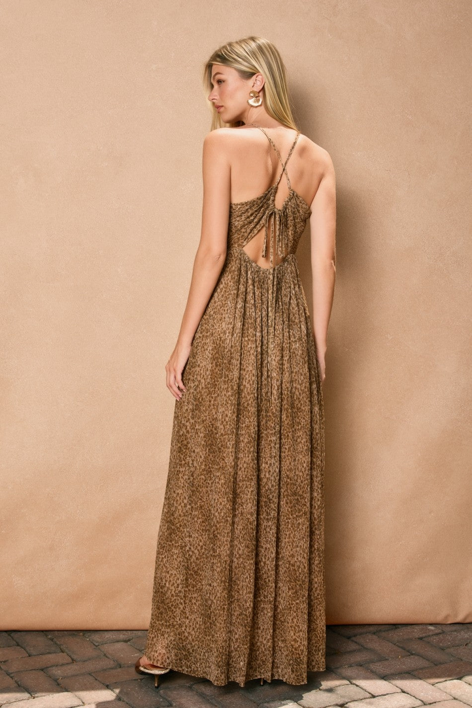 woman wearing a brown leopard print maxi dress with a crisscross back and pleated detailing