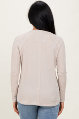 woman wearing a beige long sleeve ribbed top with a back seam detail, viewed from behind