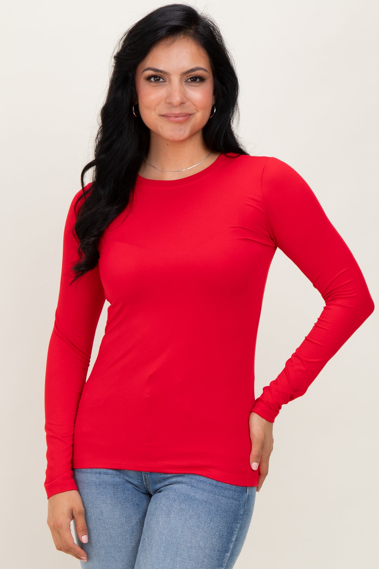 woman wearing a long sleeve bright red top with a fitted style and crew neckline