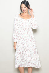 woman wearing a white polka dot midi dress with a square neckline and long sleeves