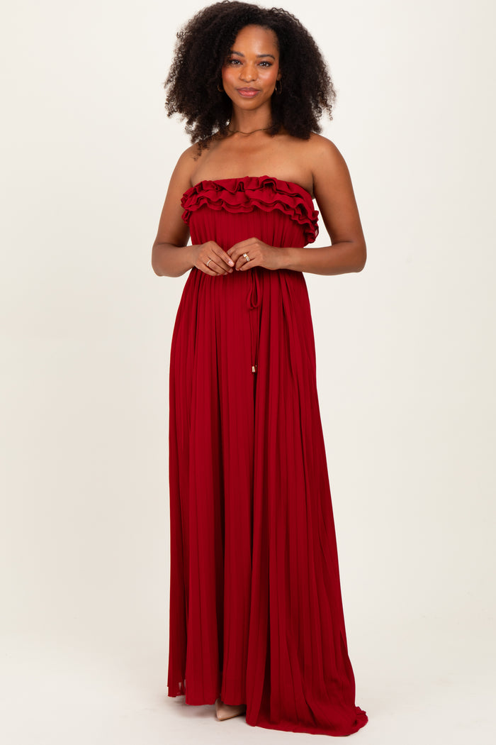 woman wearing a strapless red maxi dress with ruffle details and a gathered waist