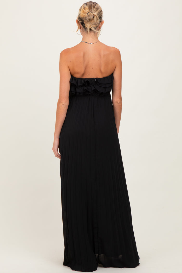 woman wearing a black strapless maternity maxi dress with ruffle detailing and pleated fabric