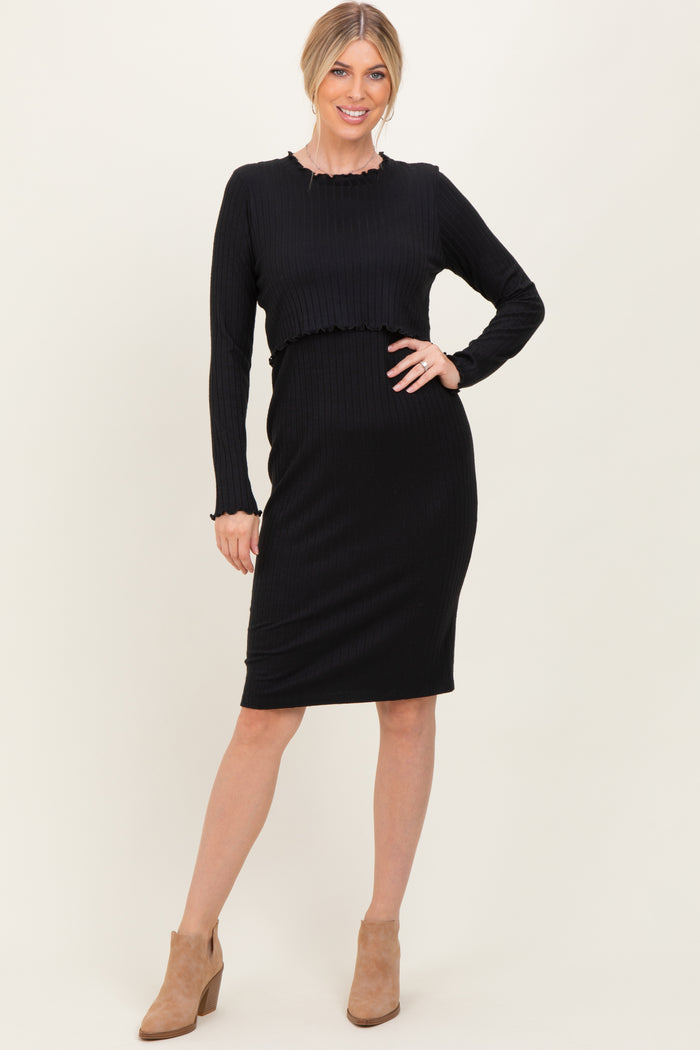 woman wearing a black ribbed two-piece dress with long sleeves and a fitted skirt, paired with tan ankle boots