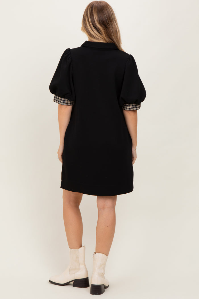 woman wearing a black short dress with plaid puff sleeves and white ankle boots, shown from the back