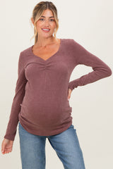 woman wearing a mauve ribbed maternity top with a V-neck and a visible baby bump