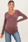 woman wearing a mauve ribbed maternity top with a V-neck and a visible baby bump