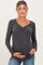 woman wearing a dark gray ribbed maternity long sleeve top and holding her baby bump