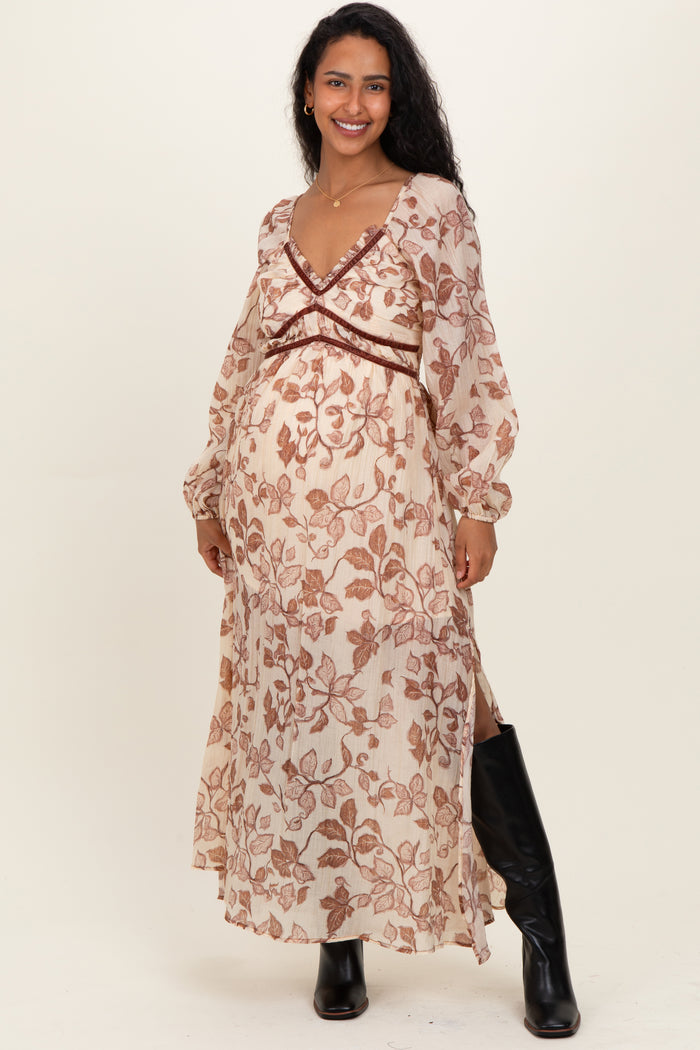 woman wearing a floral long sleeve maternity dress with a v-neckline and side slits, showing her baby bump