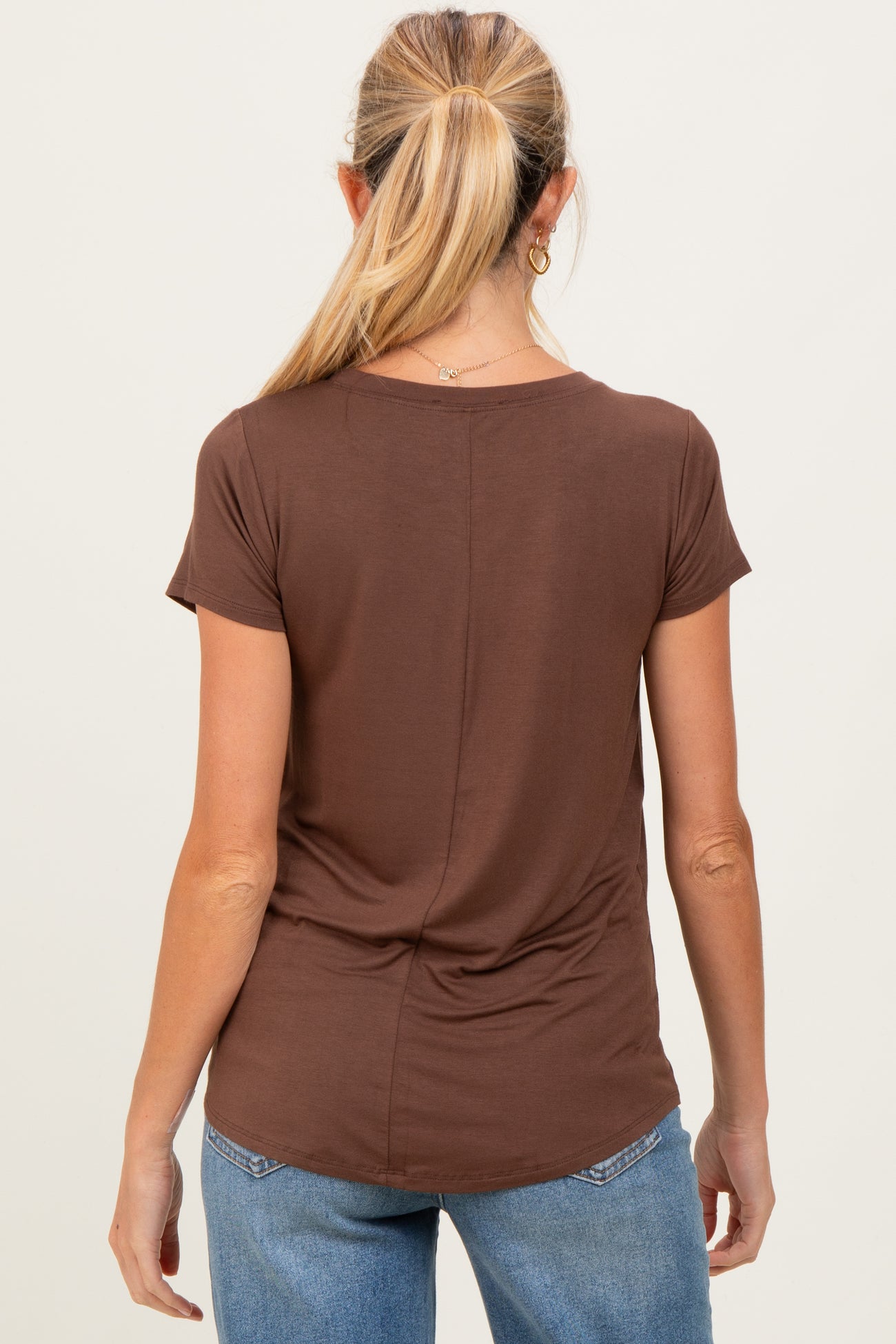 woman wearing a brown short sleeve maternity top with a ruched back, seen from the back