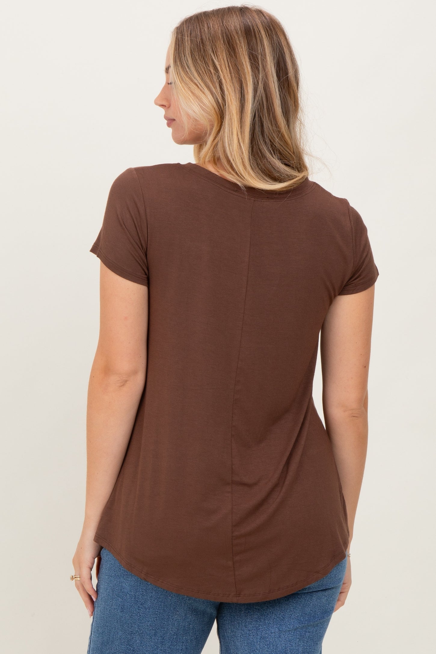 woman wearing a brown short sleeve top with a curved hemline and back seam detail