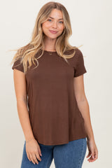 woman wearing a brown short sleeve t-shirt paired with blue jeans