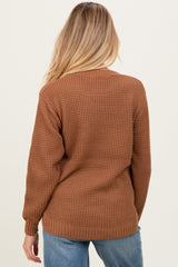 woman wearing a brown knitted maternity cardigan, viewed from the back, showcasing a relaxed fit and long sleeves