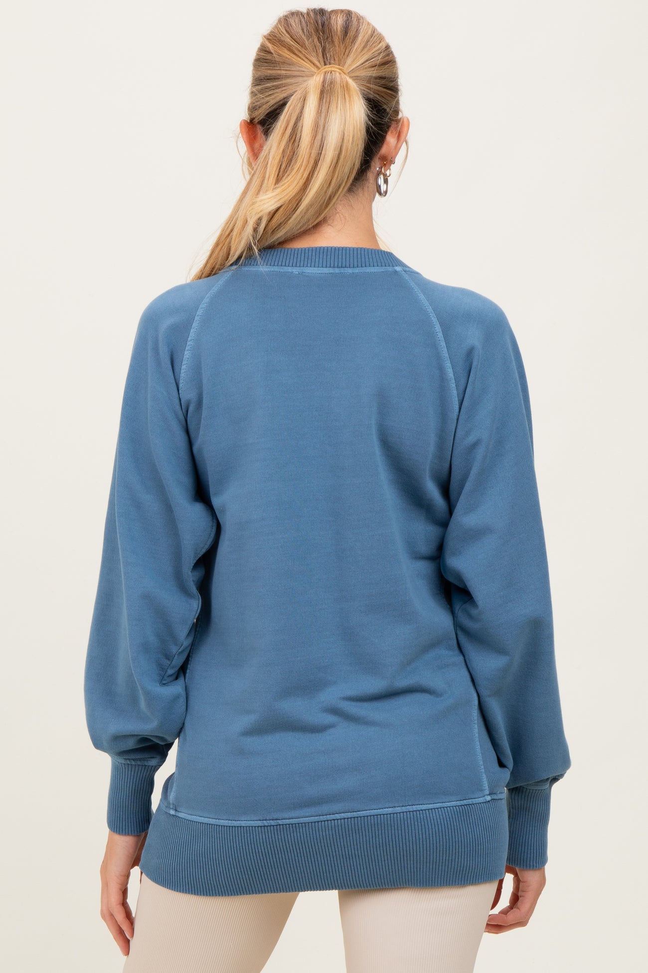 woman wearing a blue maternity sweatshirt with a relaxed fit and balloon sleeves, shown from the back