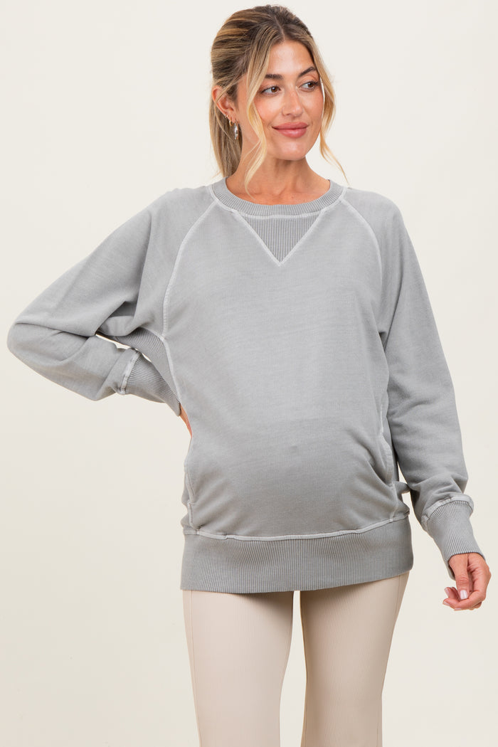 woman wearing a light gray maternity sweatshirt with a cozy fit and visible baby bump