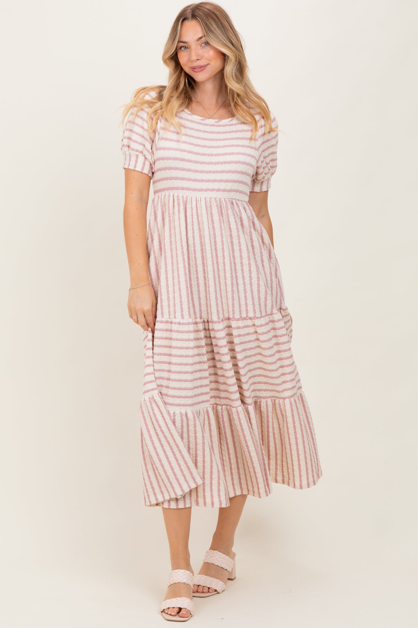 woman wearing a striped midi dress with short sleeves and tiered ruffle hem