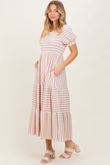 woman wearing a pink and white striped maxi dress with puff sleeves and pockets