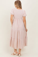 woman wearing a pink and white striped tiered maxi dress, showing the back view and short puff sleeves