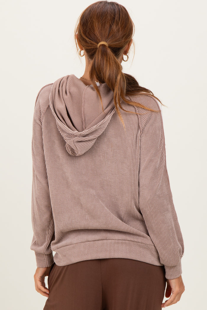 woman wearing a taupe ribbed hooded sweatshirt with a relaxed fit and long sleeves, viewed from the back