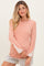 woman wearing a pink striped maternity top with lace detail on the sleeves and a relaxed fit