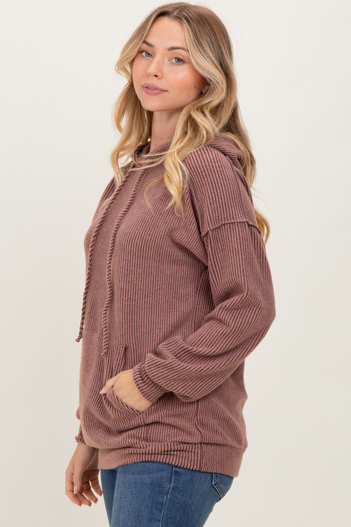woman wearing a mauve ribbed hoodie with a front pocket and drawstring detail, styled with blue jeans