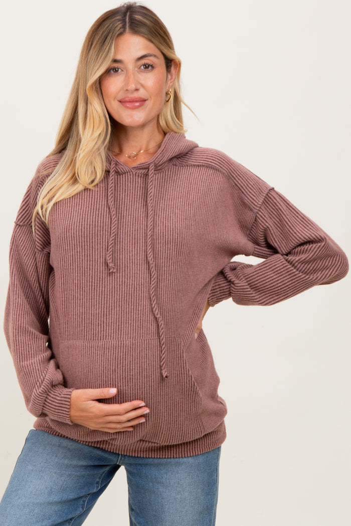 woman wearing a mauve ribbed maternity hoodie and holding her baby bump