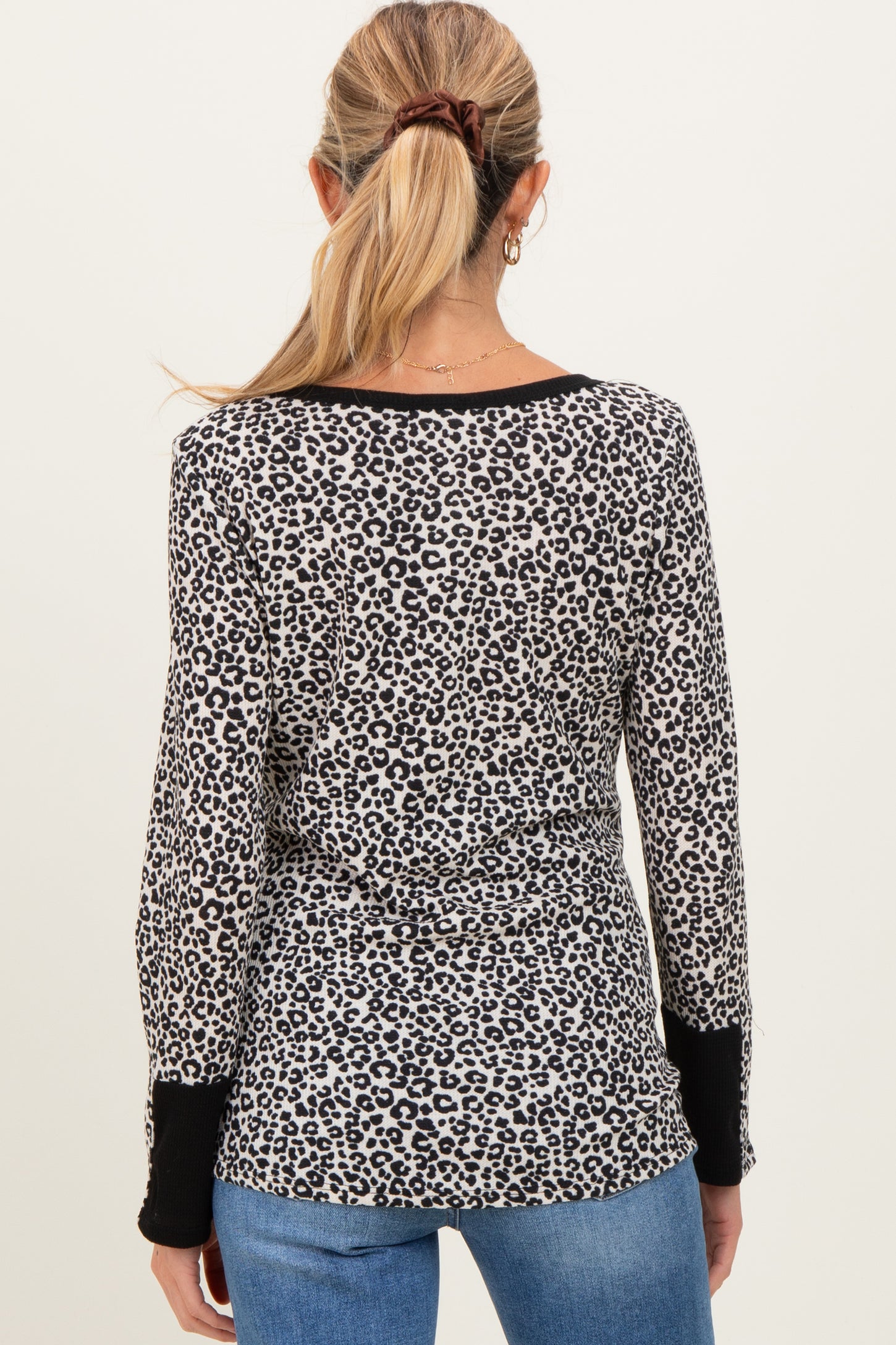 woman wearing a maternity long sleeve leopard print top with a black trim and back view displayed