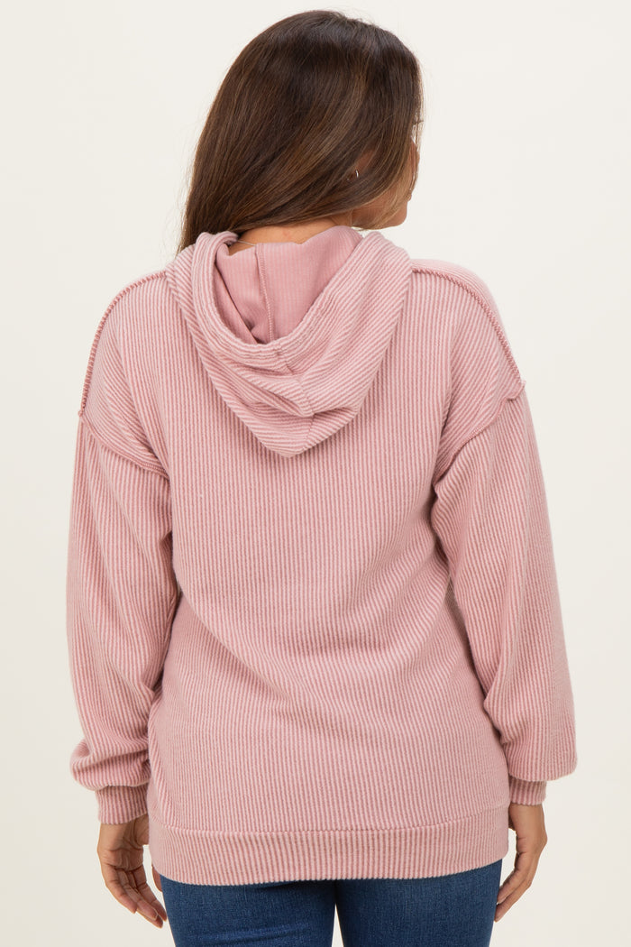 woman wearing a dusty pink ribbed hoodie, showing the back view, designed for maternity wear