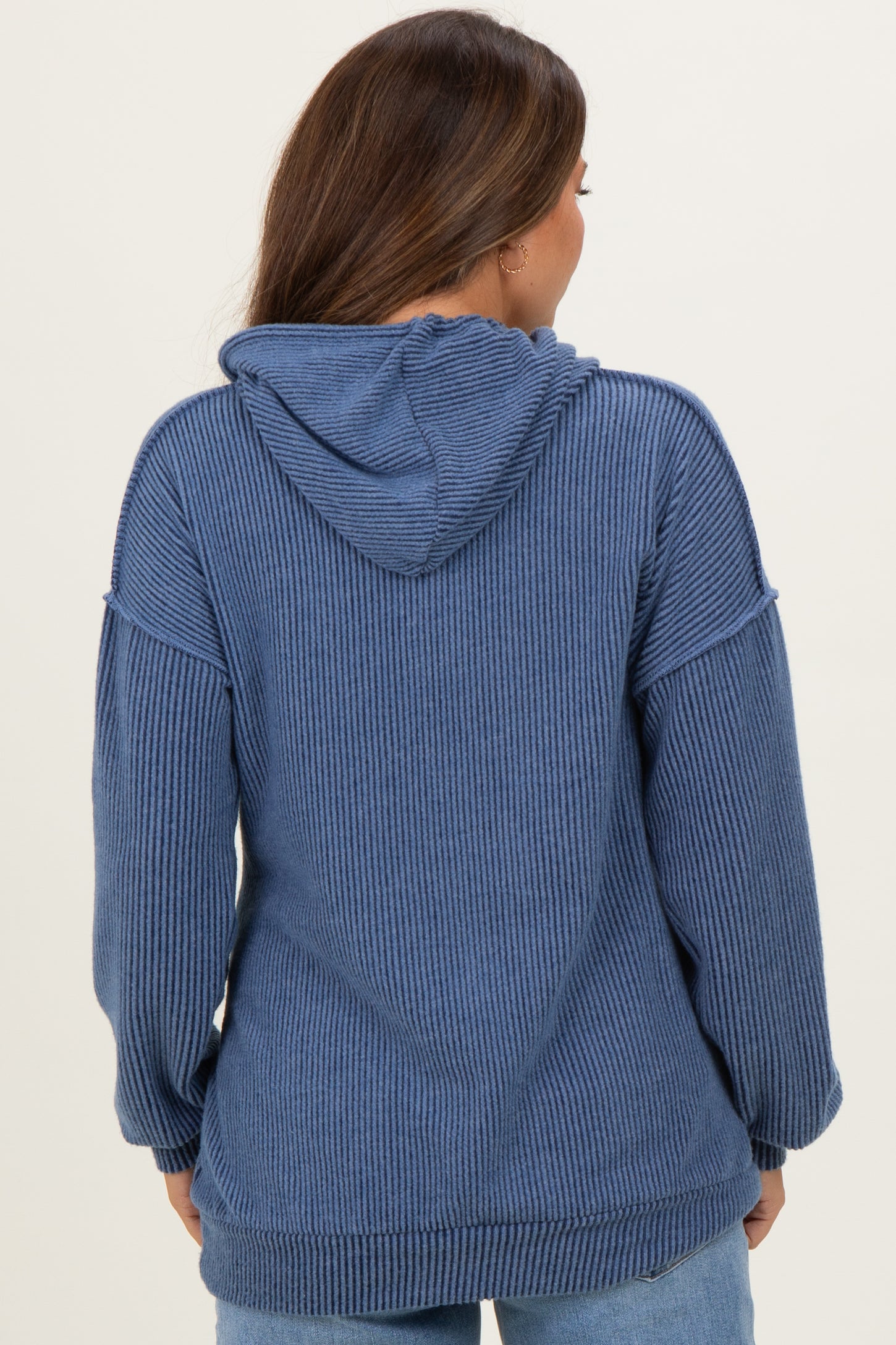 woman wearing a blue ribbed maternity hoodie with a hood and relaxed fit, showing the back view