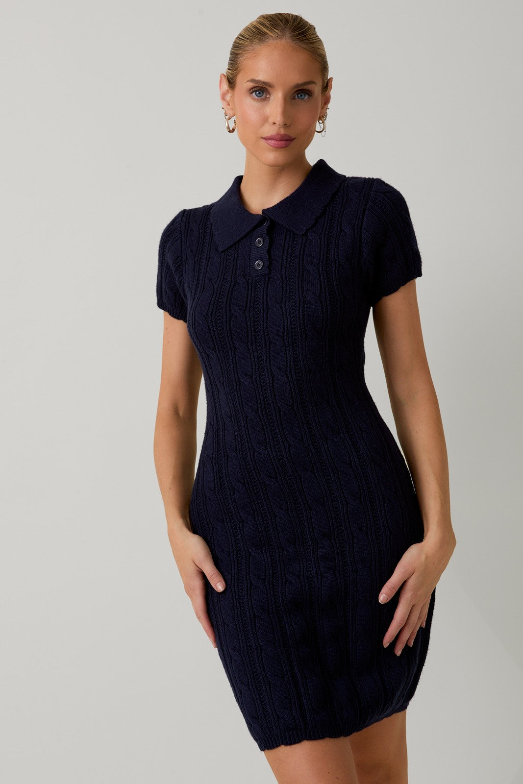 woman wearing a navy short sleeve cable knit polo dress with a fitted silhouette