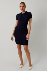 woman wearing a navy blue short sleeve polo dress with cable knit pattern and a fitted silhouette