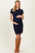 woman wearing a navy blue short sleeve knitted maternity dress and holding her baby bump
