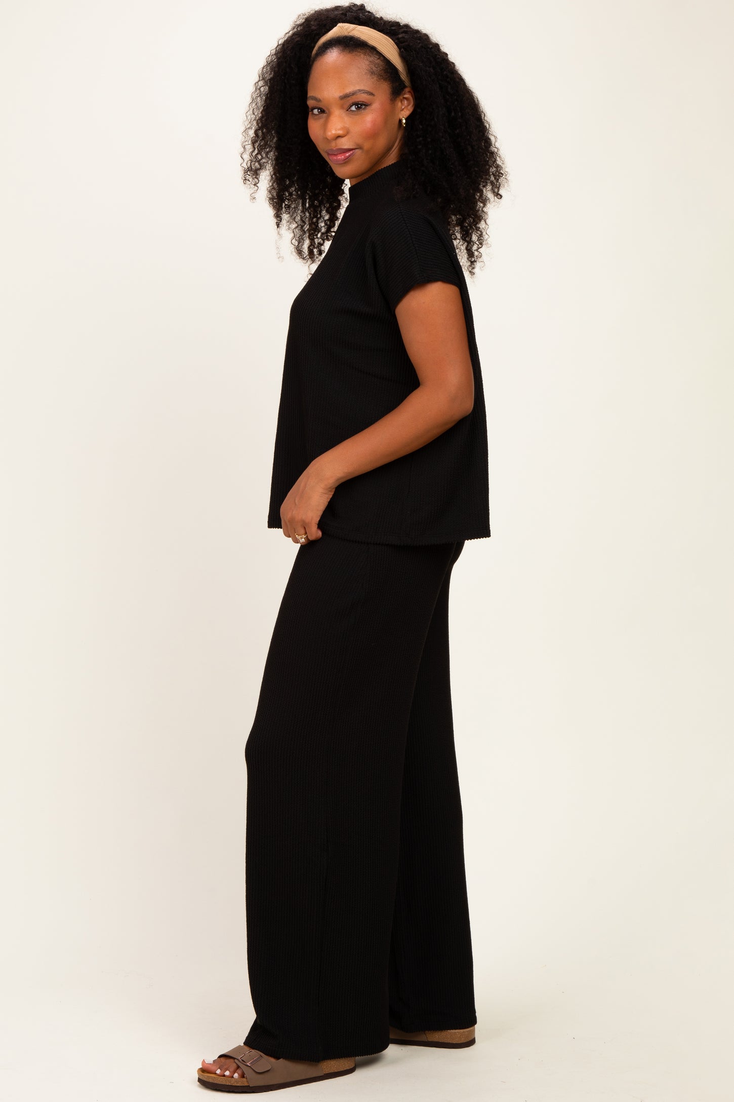 woman wearing a black ribbed short sleeve top and black wide-leg pants