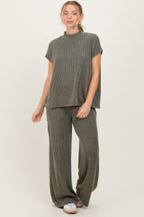 woman wearing a ribbed olive green short sleeve top and matching wide-leg pants, standing against a neutral background