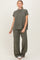 woman wearing a ribbed olive green short sleeve top and matching wide-leg pants, standing against a neutral background