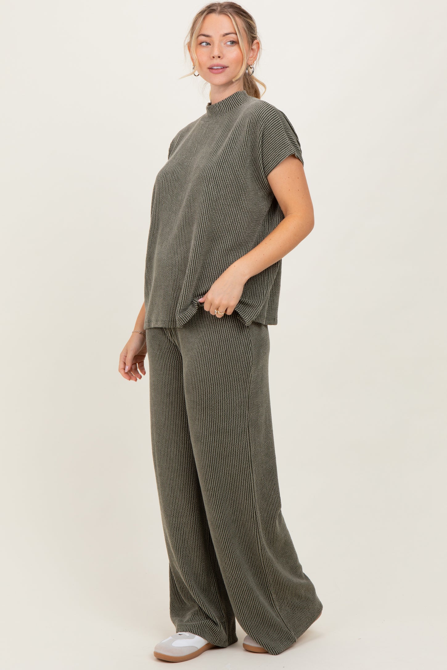 woman wearing a green ribbed matching set consisting of a short sleeve top and wide leg pants