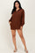 woman wearing a brown long sleeve pullover dress with a zip collar and side pockets