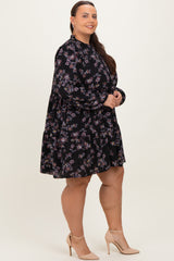woman wearing a black floral plus-size dress with long sleeves and a tiered skirt, paired with nude heels