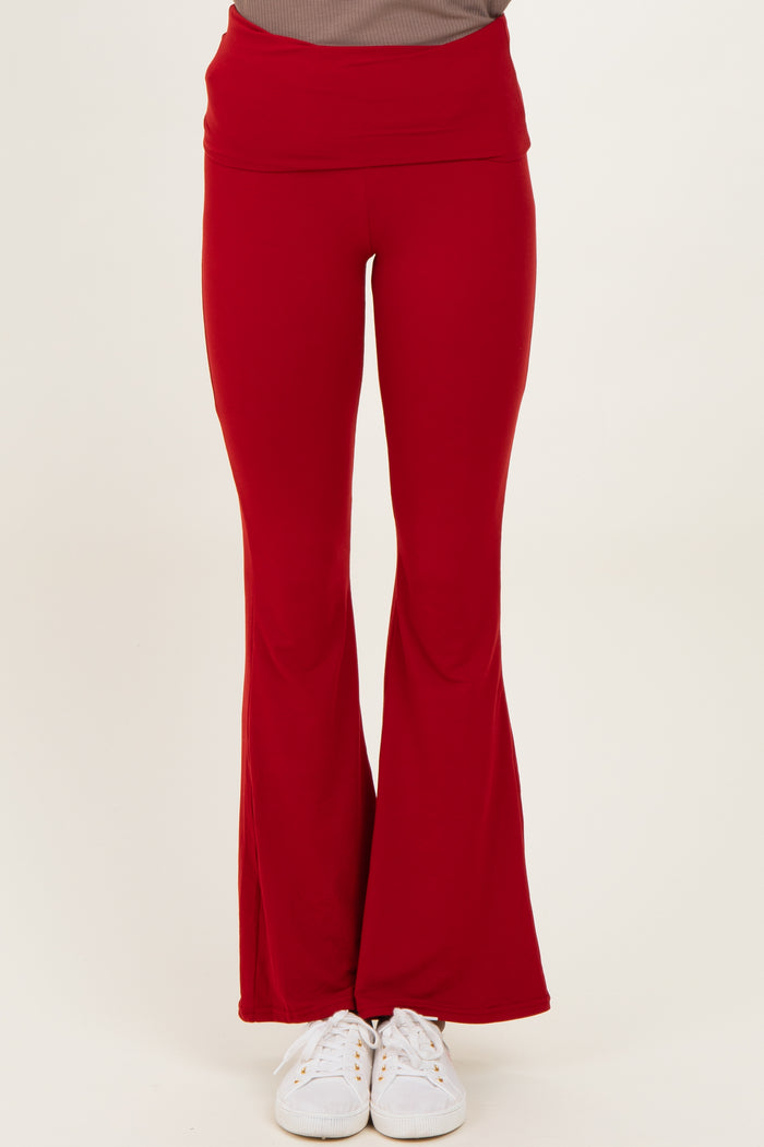 woman wearing red flared yoga pants with a high waistband and white sneakers