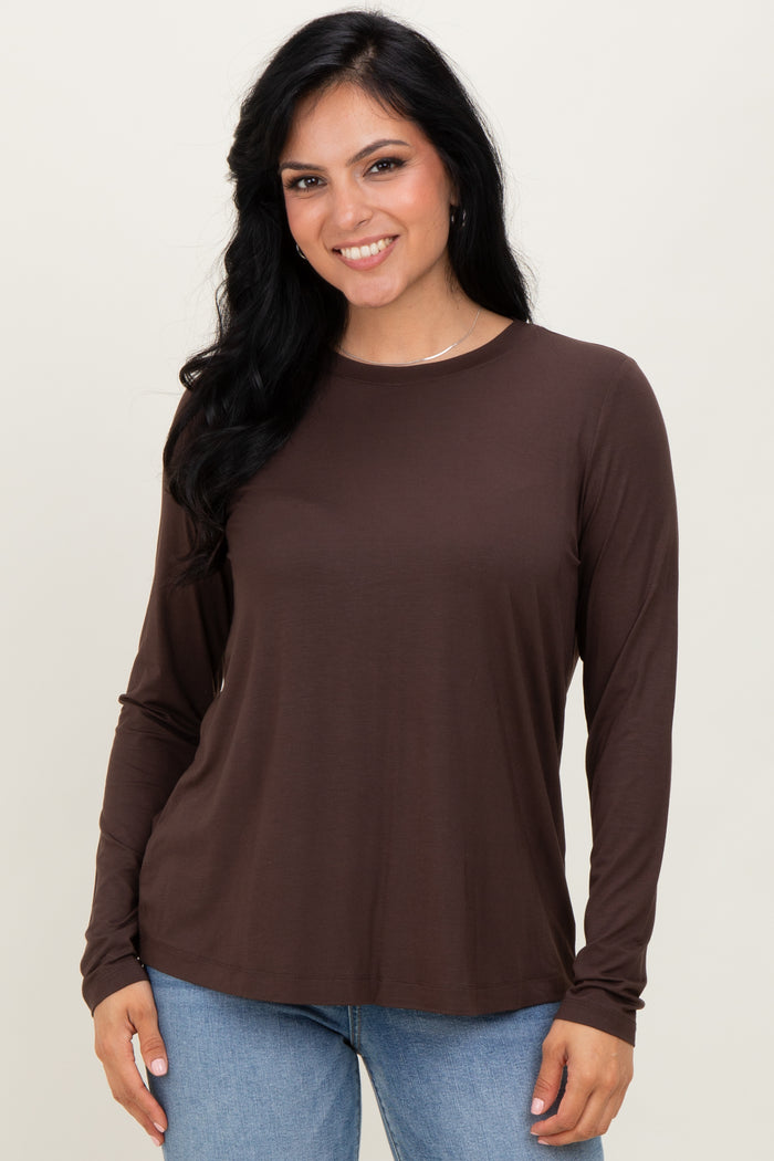 woman wearing a brown long sleeve top paired with light blue jeans
